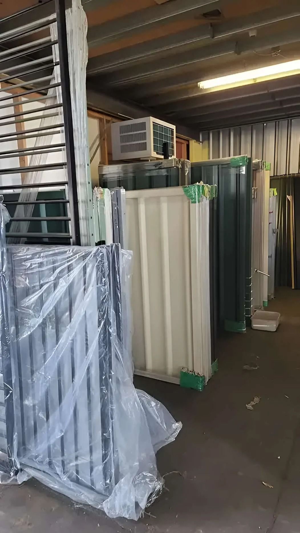 Metal Storage Units and Fencing Wrapped in Plastic Inside a Warehouse — Metal Fencing Supplies In Taree, NSW