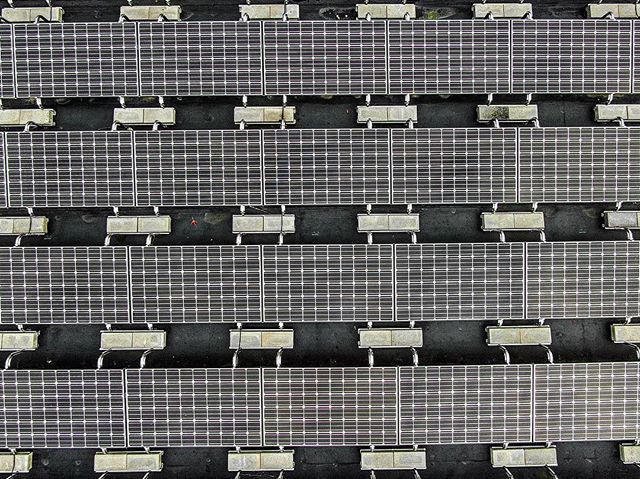 Hudson Valley Drones aerial view of a row of solar panels on a building.