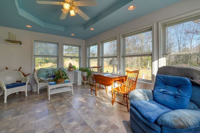 Modern living room featuring a blue chair, table, and ceiling fan with contemporary decor.