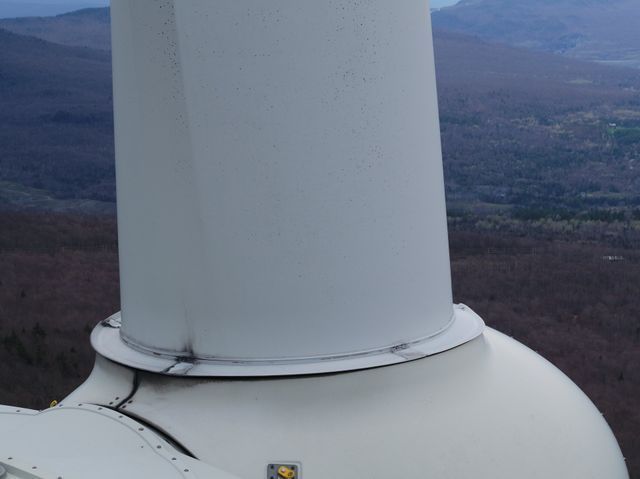 Hudson Valley Drones close-up of a wind turbine with mountains in the background.