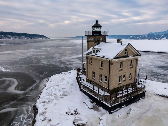 Aerial photography of lighthouse surrounded by snow and ice.