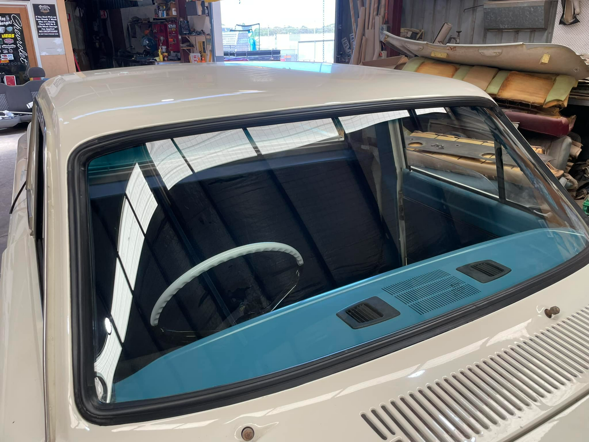 A White Car With A Blue Dashboard Is Parked In A Garage — Bendigo Windscreens in Bendigo, VIC