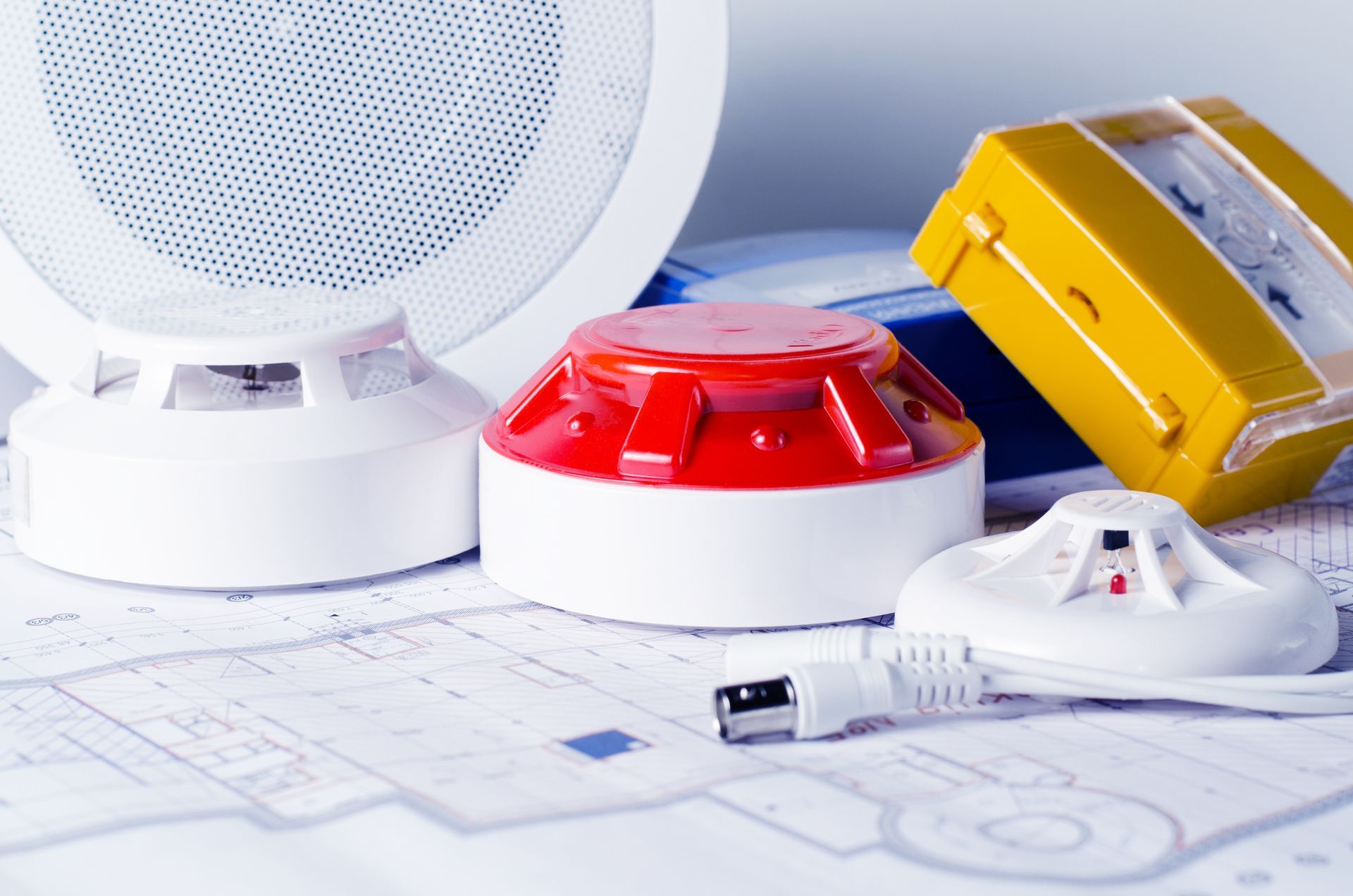 Fire Surveillance Security Systems equipment and blueprint on a planning table.