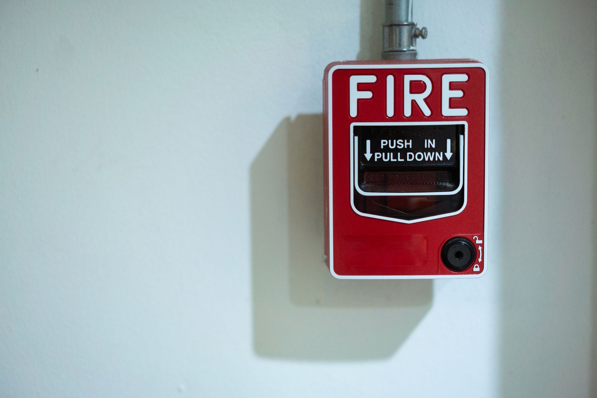 Fire alarm signal mounted on a brick wall, indicating emergency alert system.