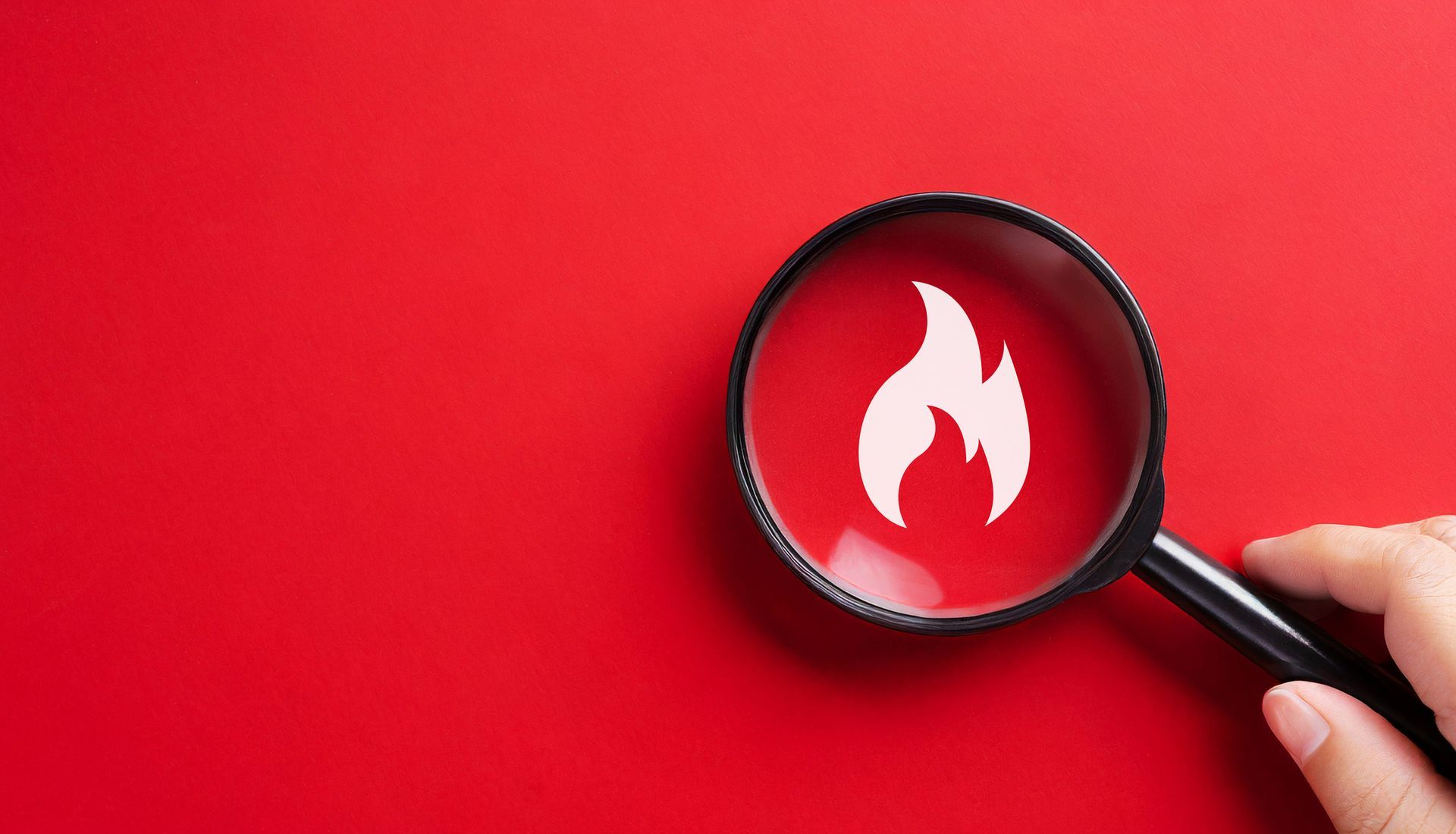 Magnifying glass with flame icon representing fire surveillance security systems concept.
