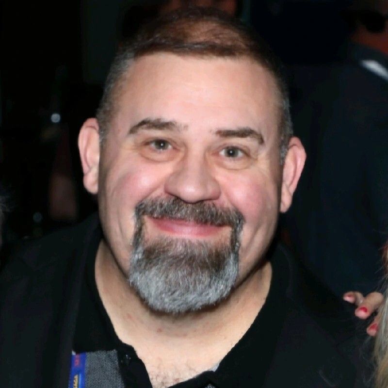 Man with short, dark hair and goatee smiles at the camera.