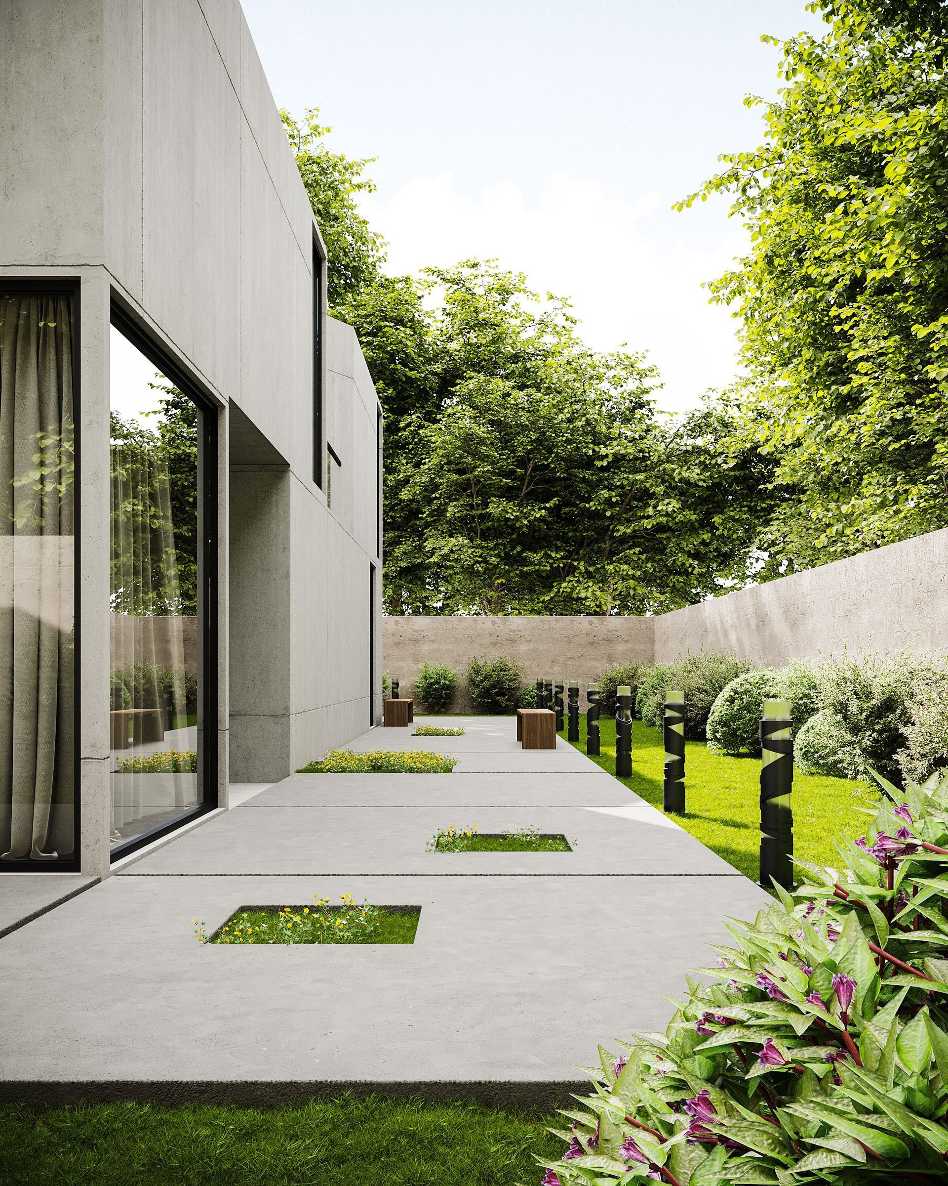 Curved garden bed with green and purple plants beside a stone pathway in a landscaped yard