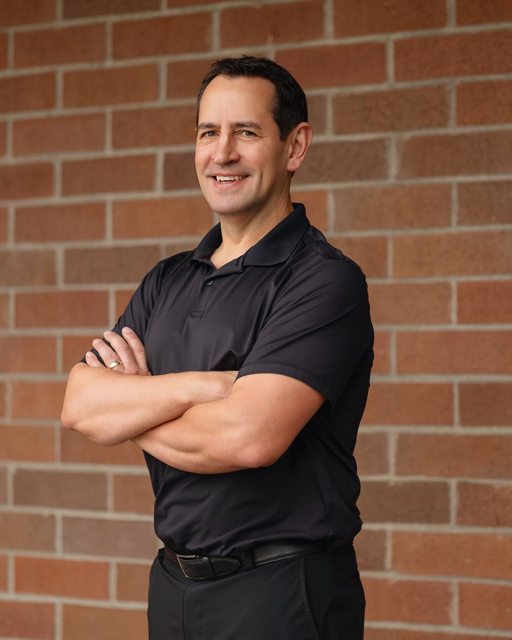 A man in a black scrub is holding a stethoscope in his hand.