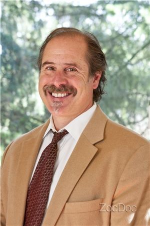 A man in a suit and tie is smiling for the camera.