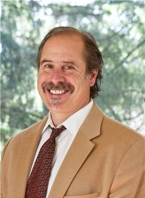 A man in a suit and tie is smiling for the camera.