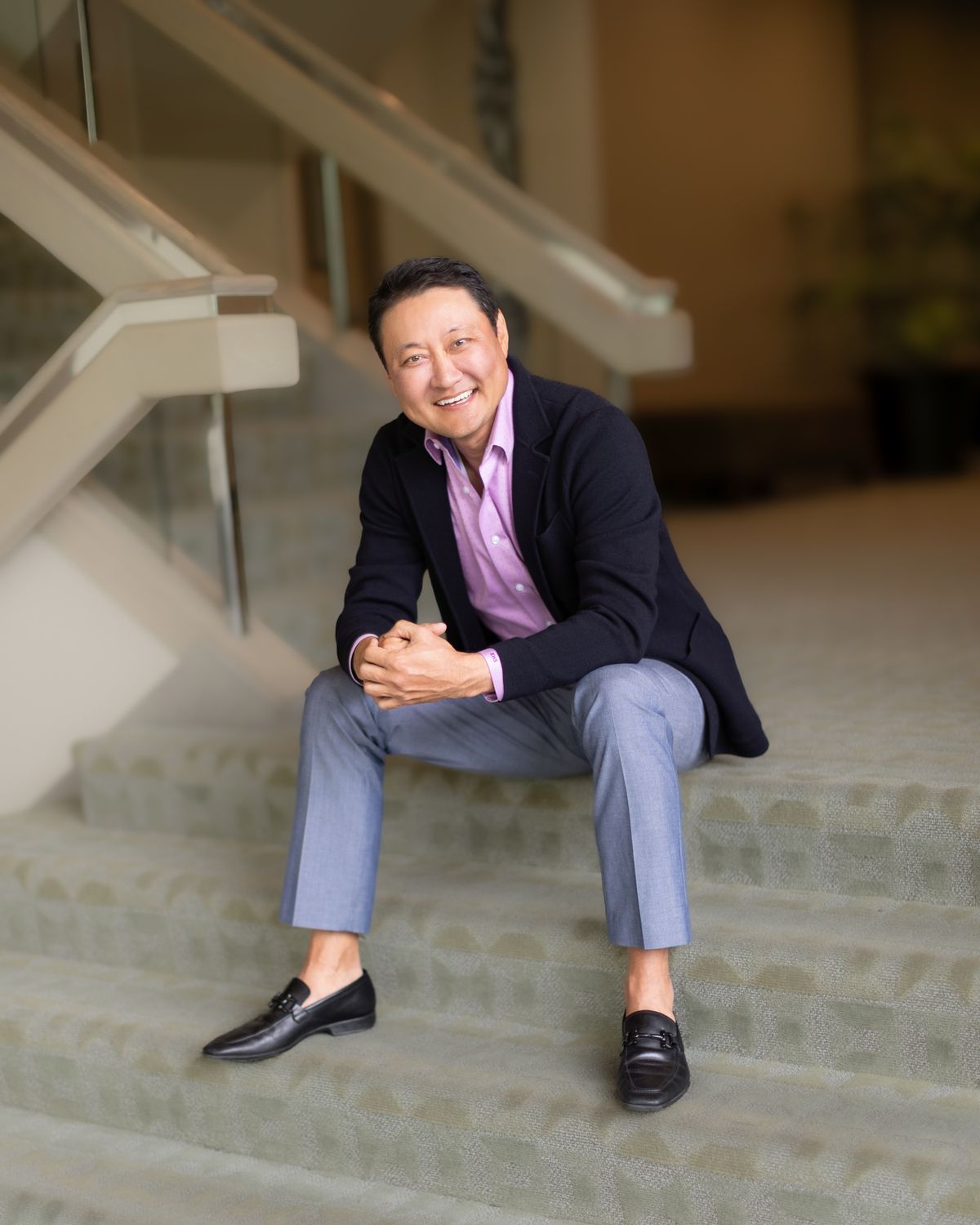 A man in a suit is sitting on a set of stairs