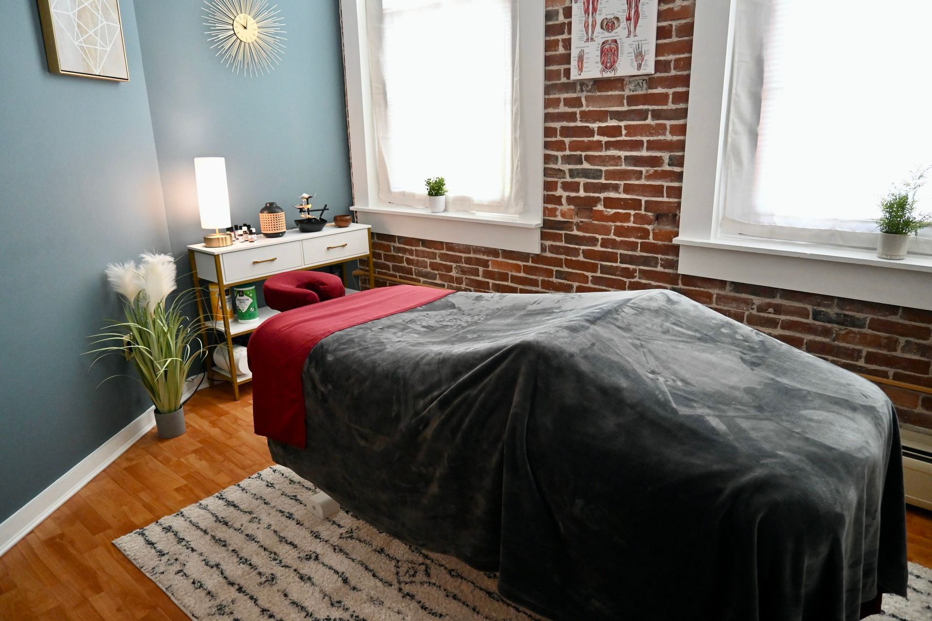 A massage table is sitting in a room with a brick wall.