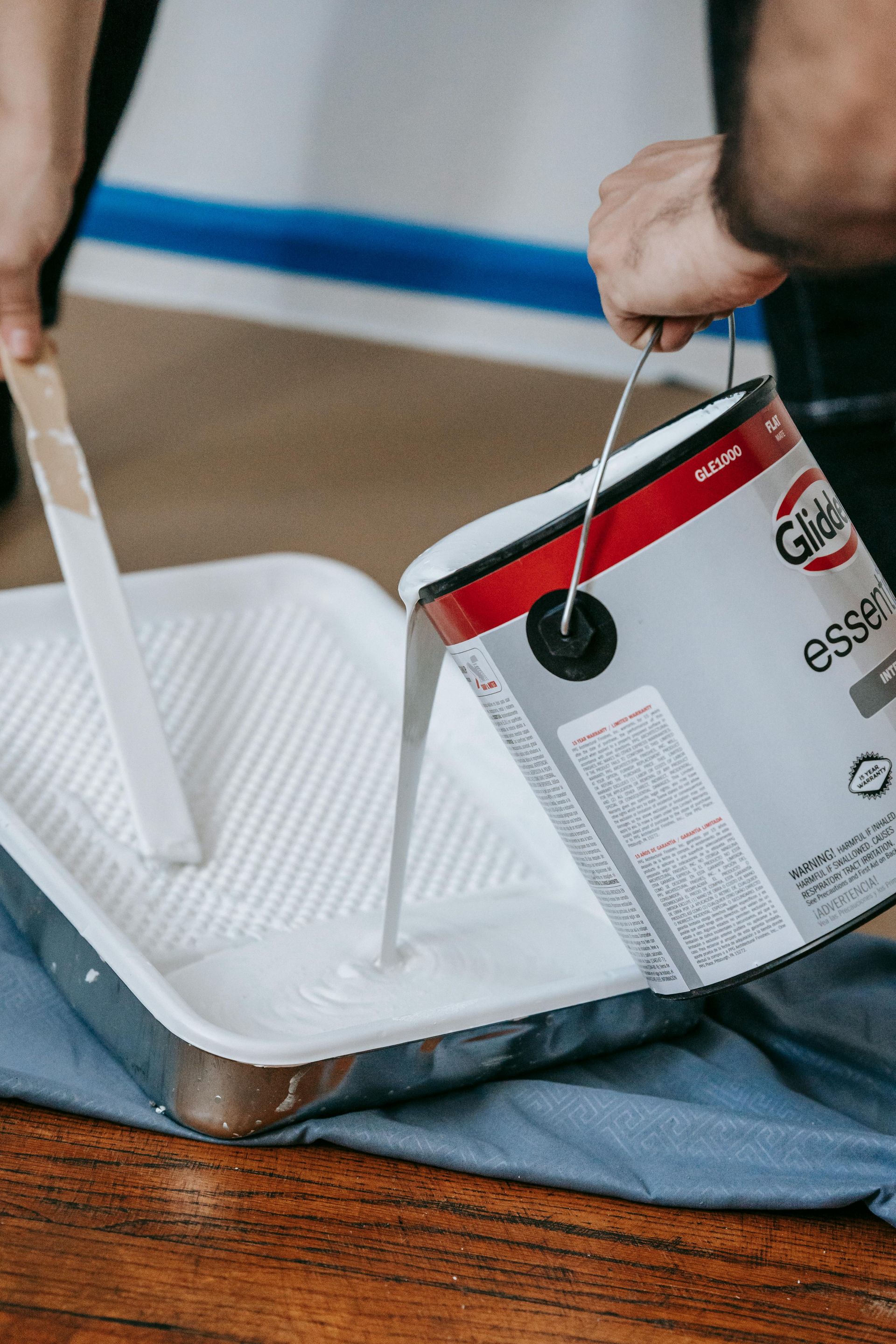 Close-up of a painter using a roller to apply white paint on an interior wall in Sierra Vista, AZ.