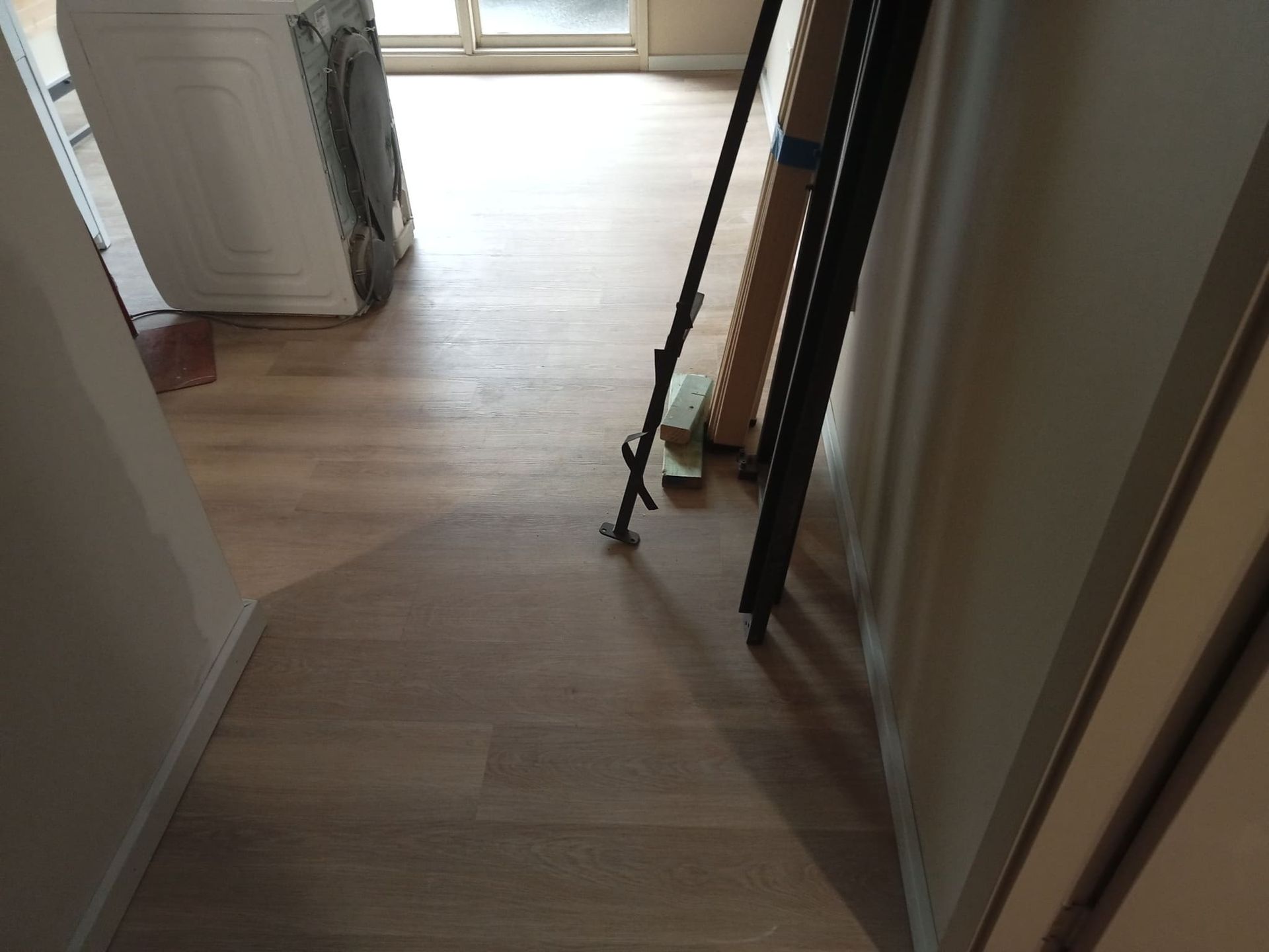 A Hallway With a Wooden Floor and a Ladder on the Floor — BLB Flooring Solutions in Central Coast, NSW