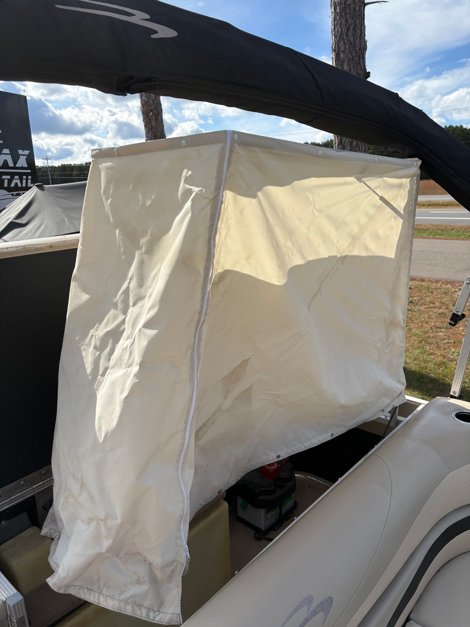 White rectangular fabric shelter on a boat, against a black canopy.