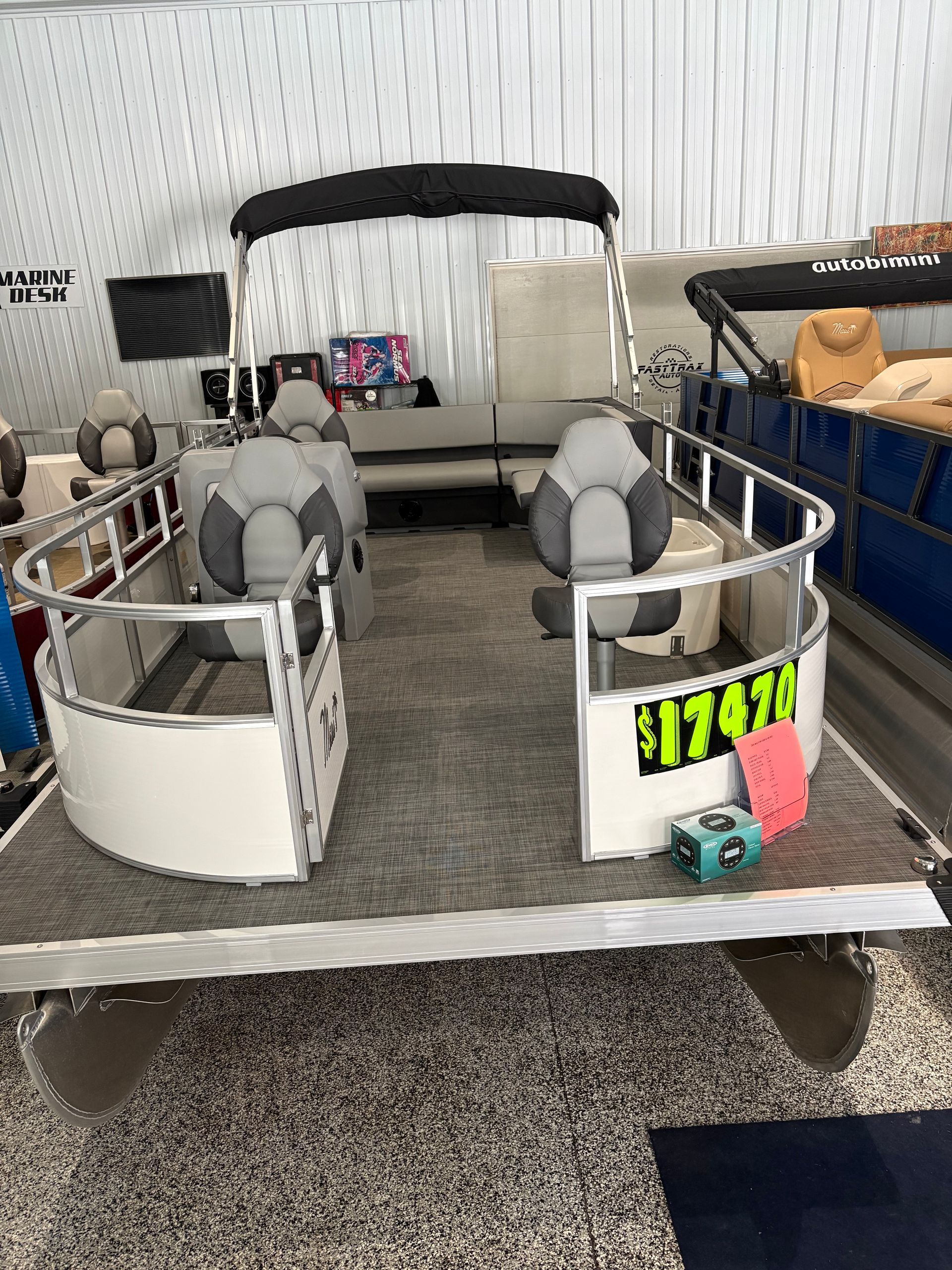 Pontoon boat with gray interior and black canopy; price tag $17,470.