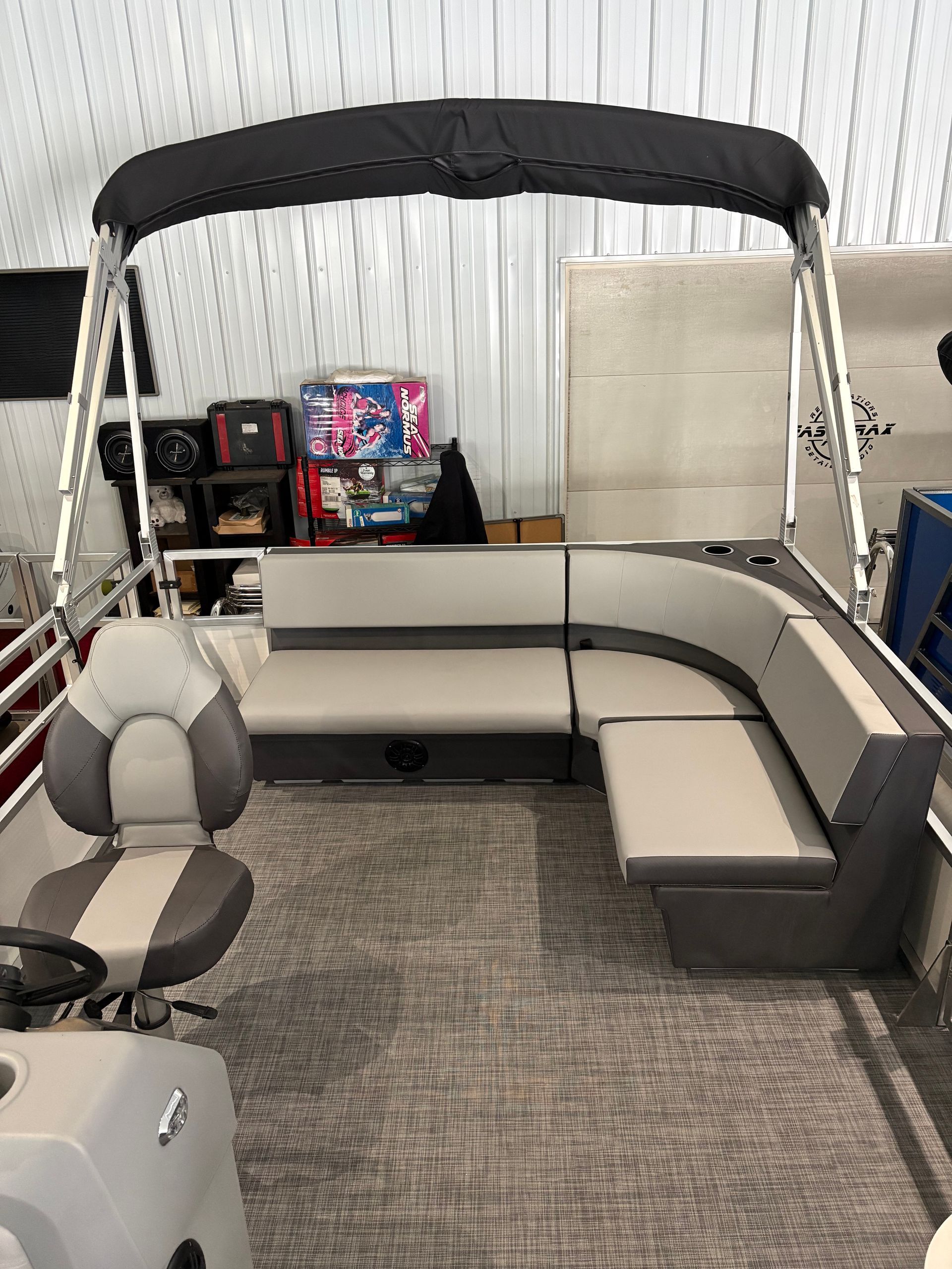 Pontoon boat interior with light gray seating and black canopy.
