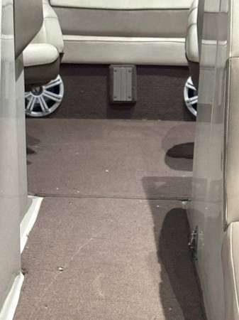 Interior of a boat with brown carpet and seating.