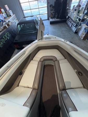 Boat interior with white and brown upholstery; dark car outside; indoors.