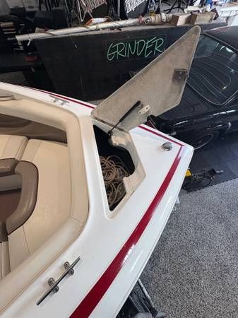 White boat with red stripe; open hatch revealing storage.
