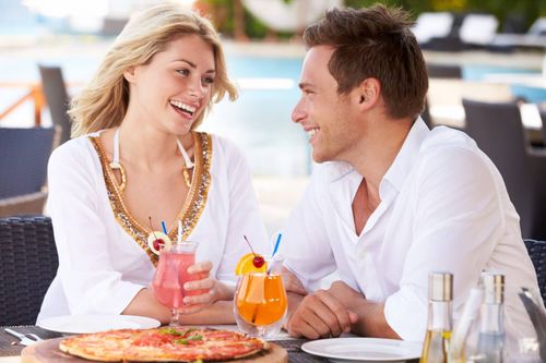 Coppia felice fa pranzo al ristorante con piscina all'aperto