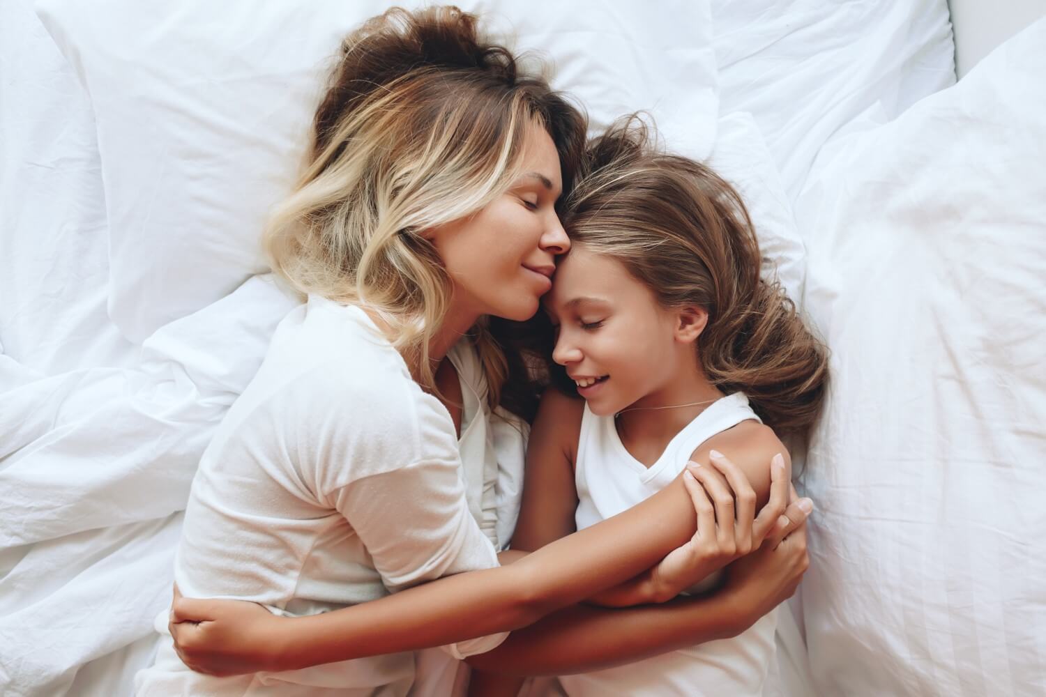 Madre e figlia abbracciate a letto
