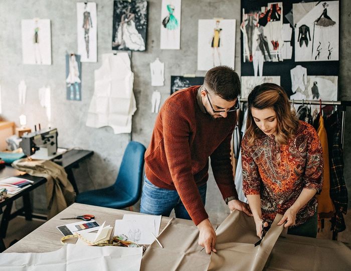 Man and woman designing clothing in studio space