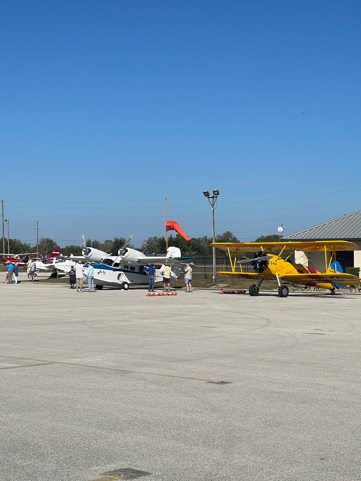 A row of small planes are parked in a parking lot