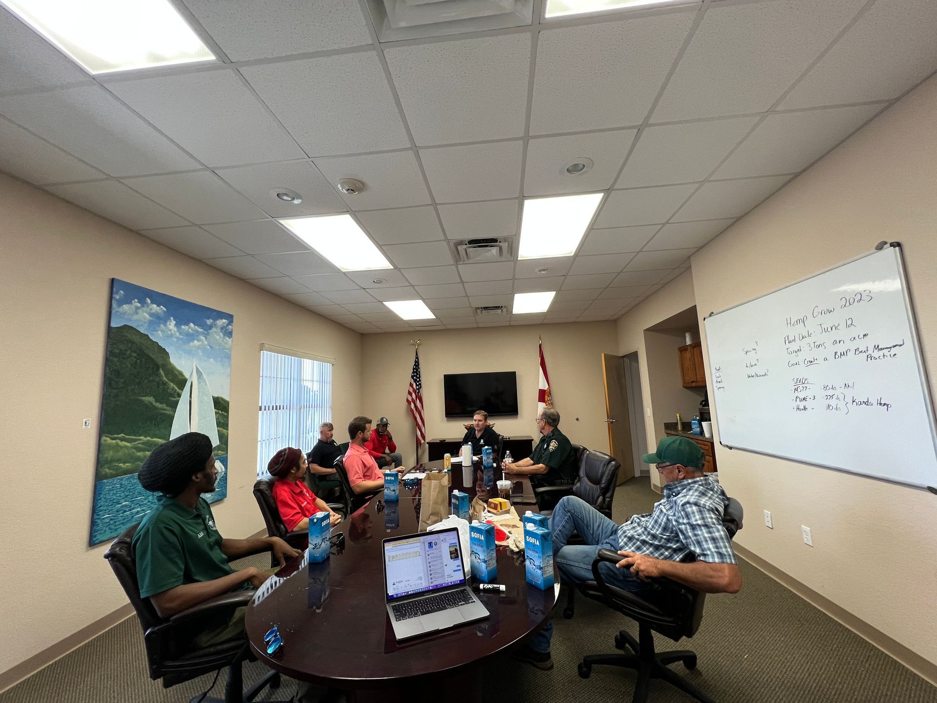 A group of people are sitting around a table in a conference room.