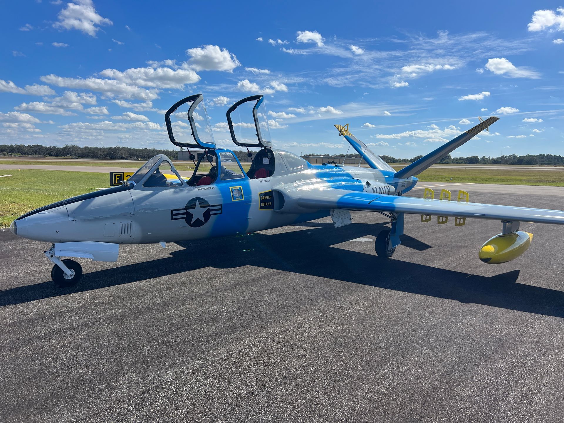 A blue and white airplane is parked on a runway.