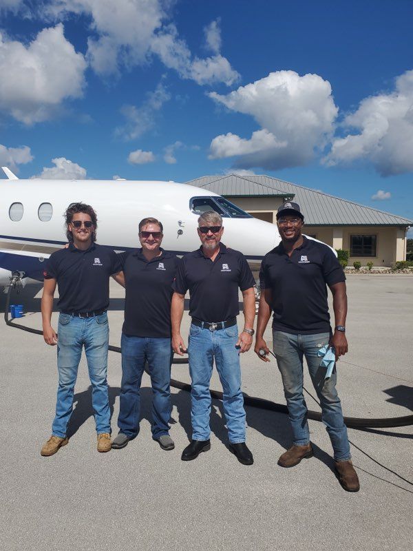 A group of men standing in front of an airplane