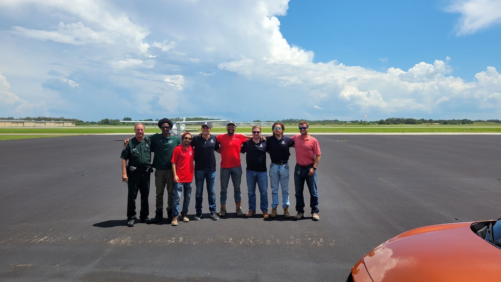 A group of men are posing for a picture on a runway