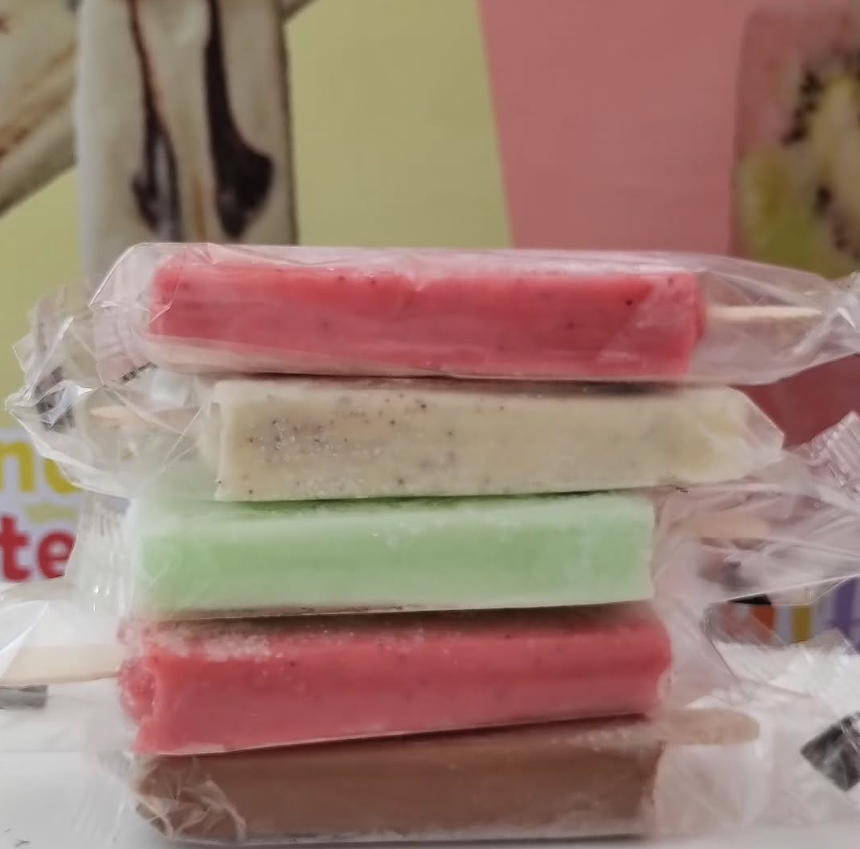 Pila de paletas de hielo envueltas en color rosa, blanco, verde y marrón.