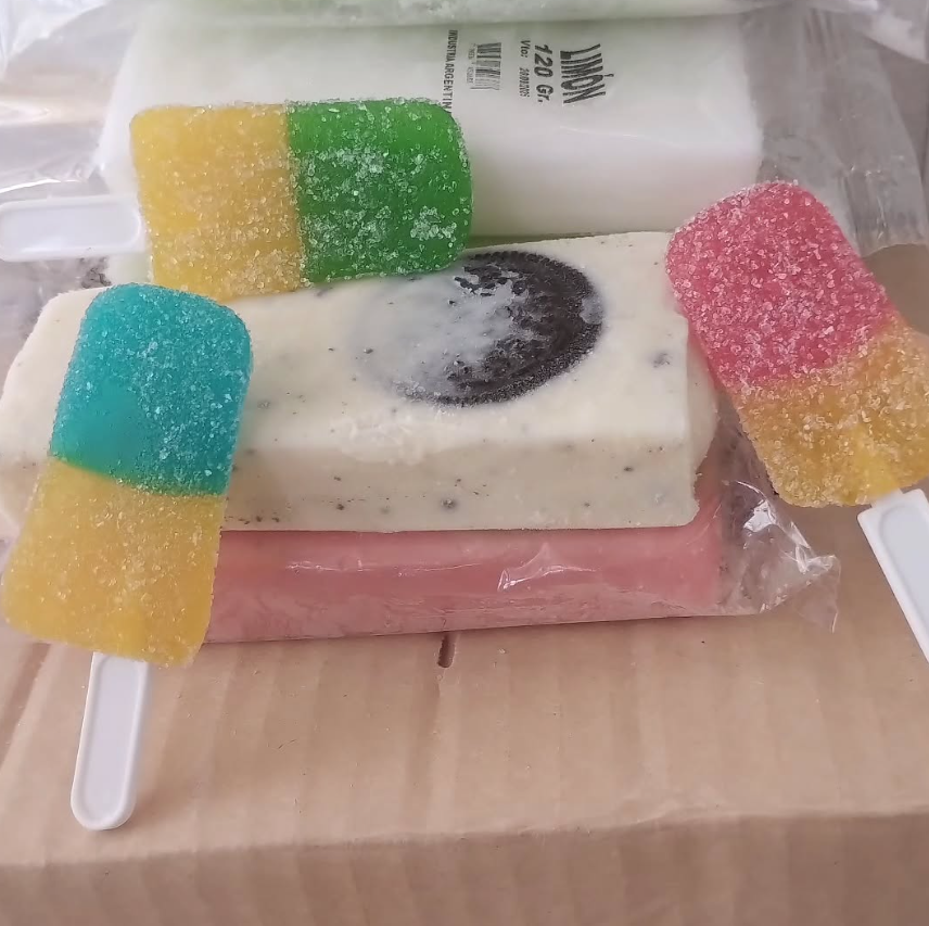 Varias paletas heladas de colores, incluidos caramelos gomosos, sobre una superficie cubierta con papel marrón.