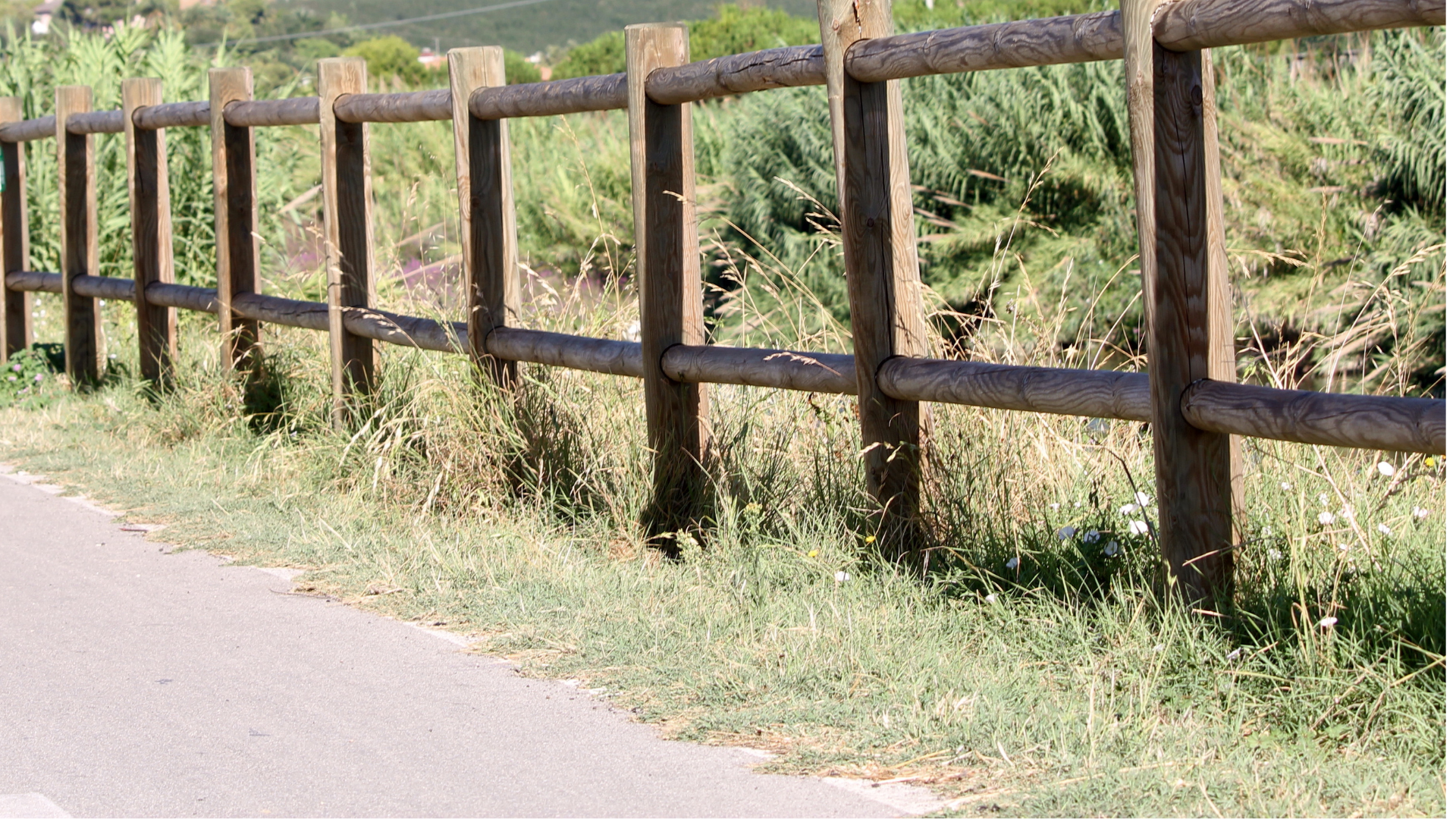 a wooden fence along the side of a road