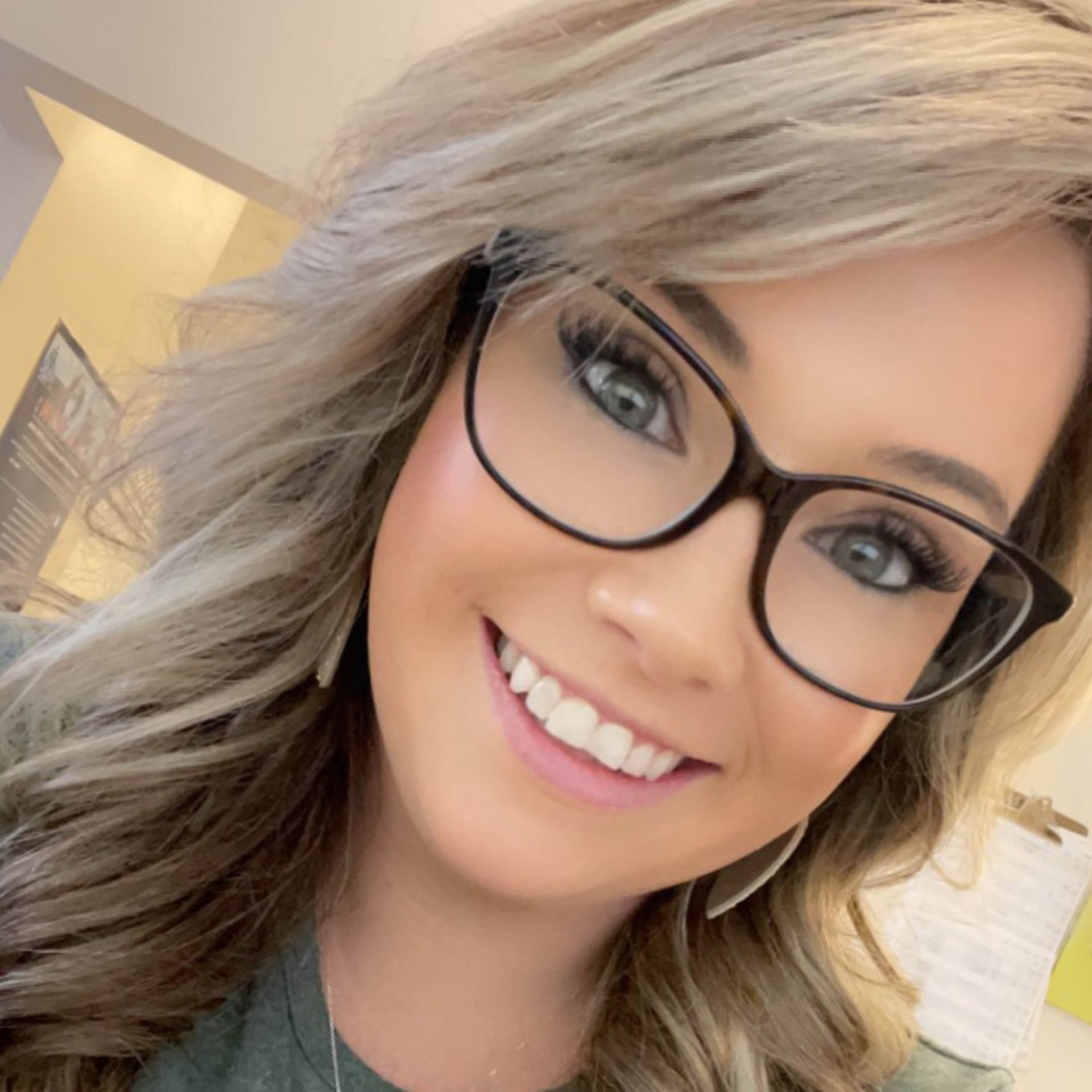 A close-up of amber montague wearing glasses and smiling.