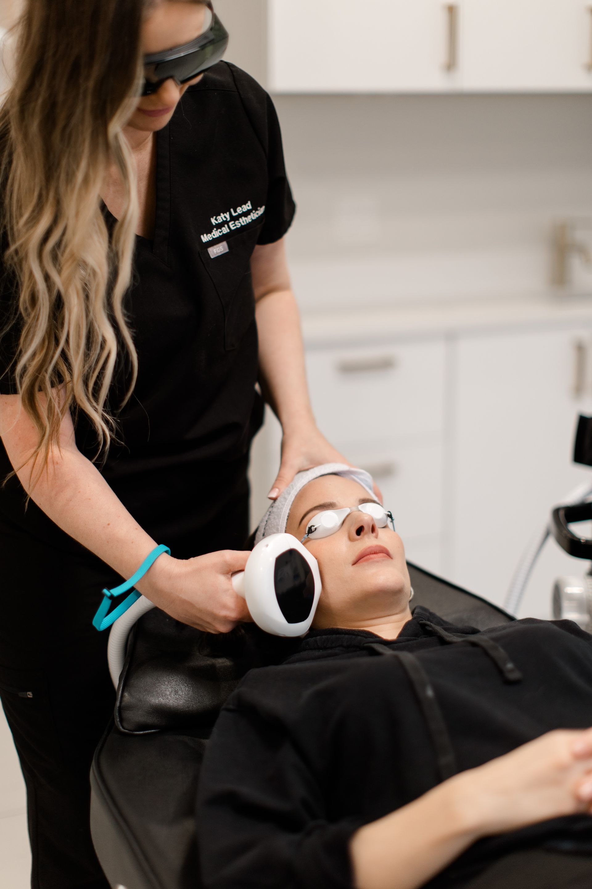 A woman is getting a laser treatment on her face.