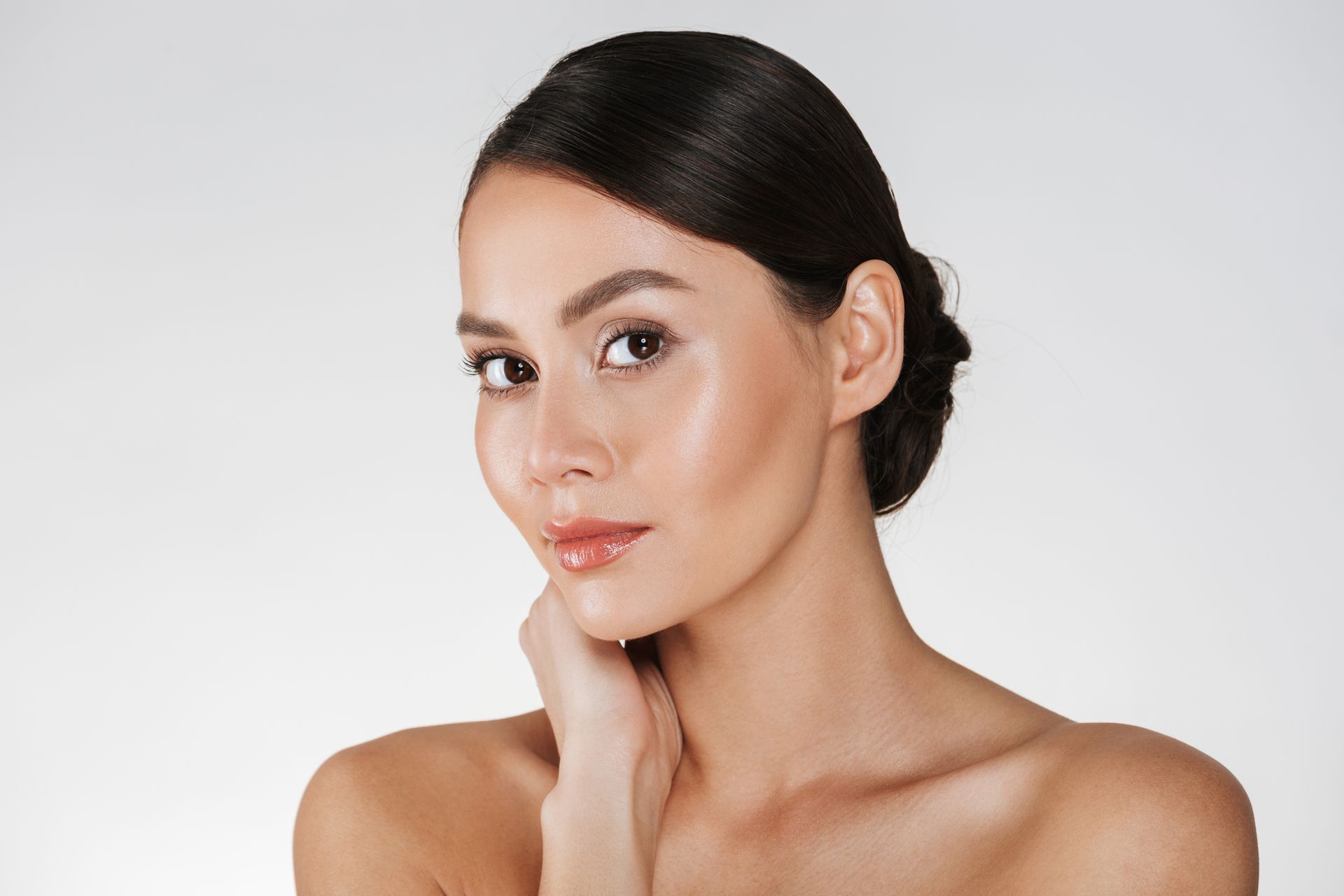 A close up of a woman 's face with her hand on her chin.