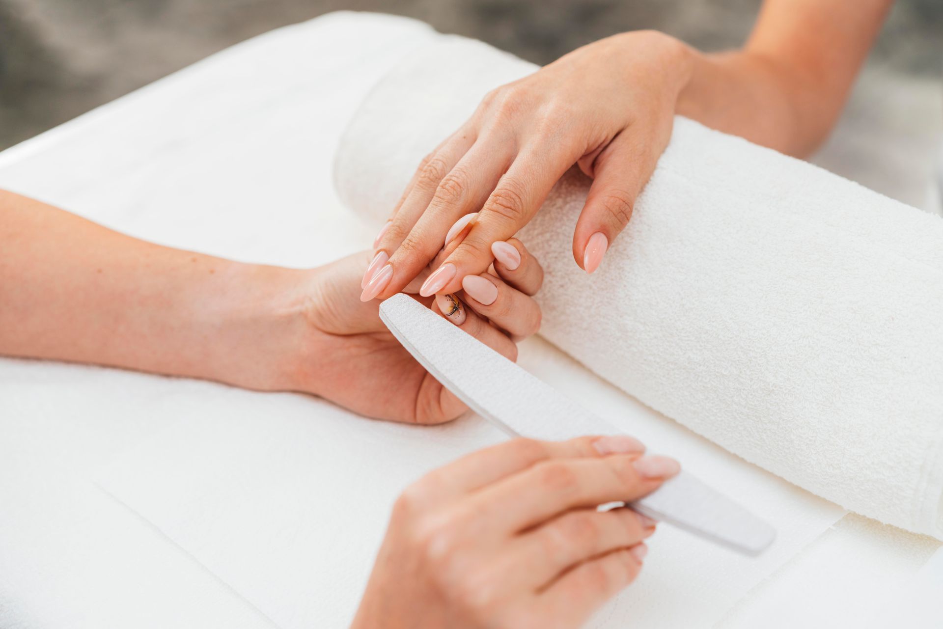 A woman is getting her nails done at a nail salon.