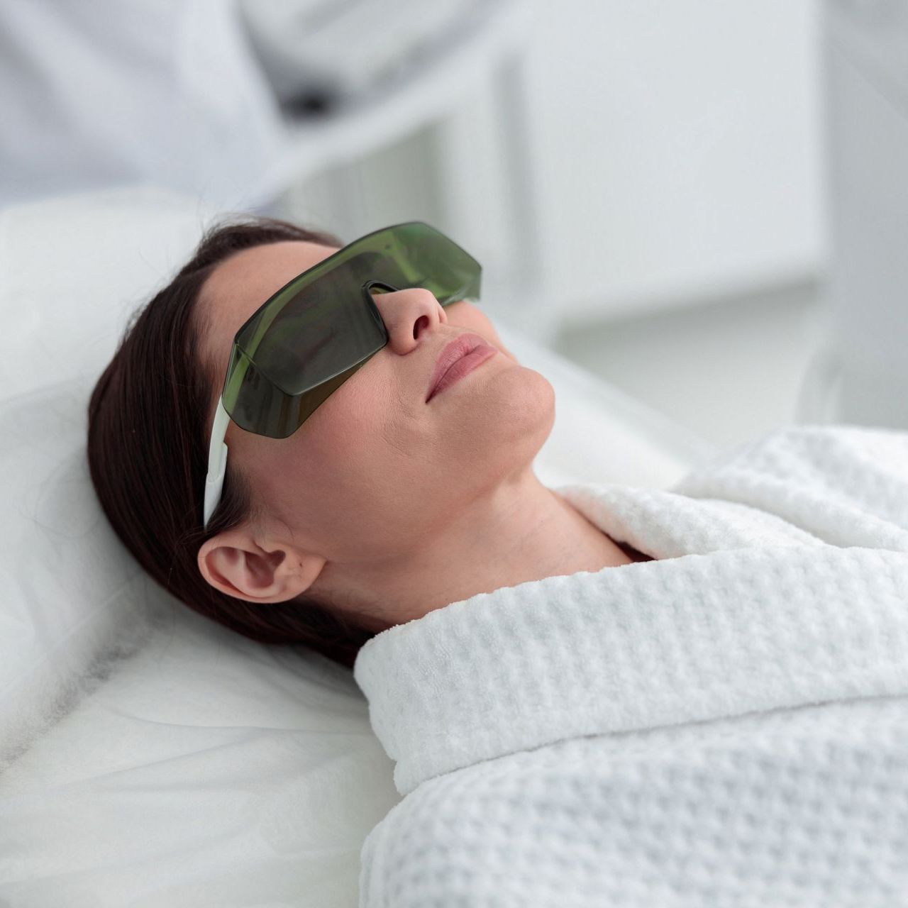 A woman is getting a laser treatment on her face
