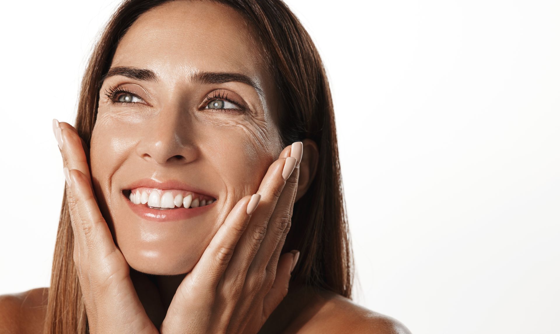 Smiling woman holding her face with both hands.