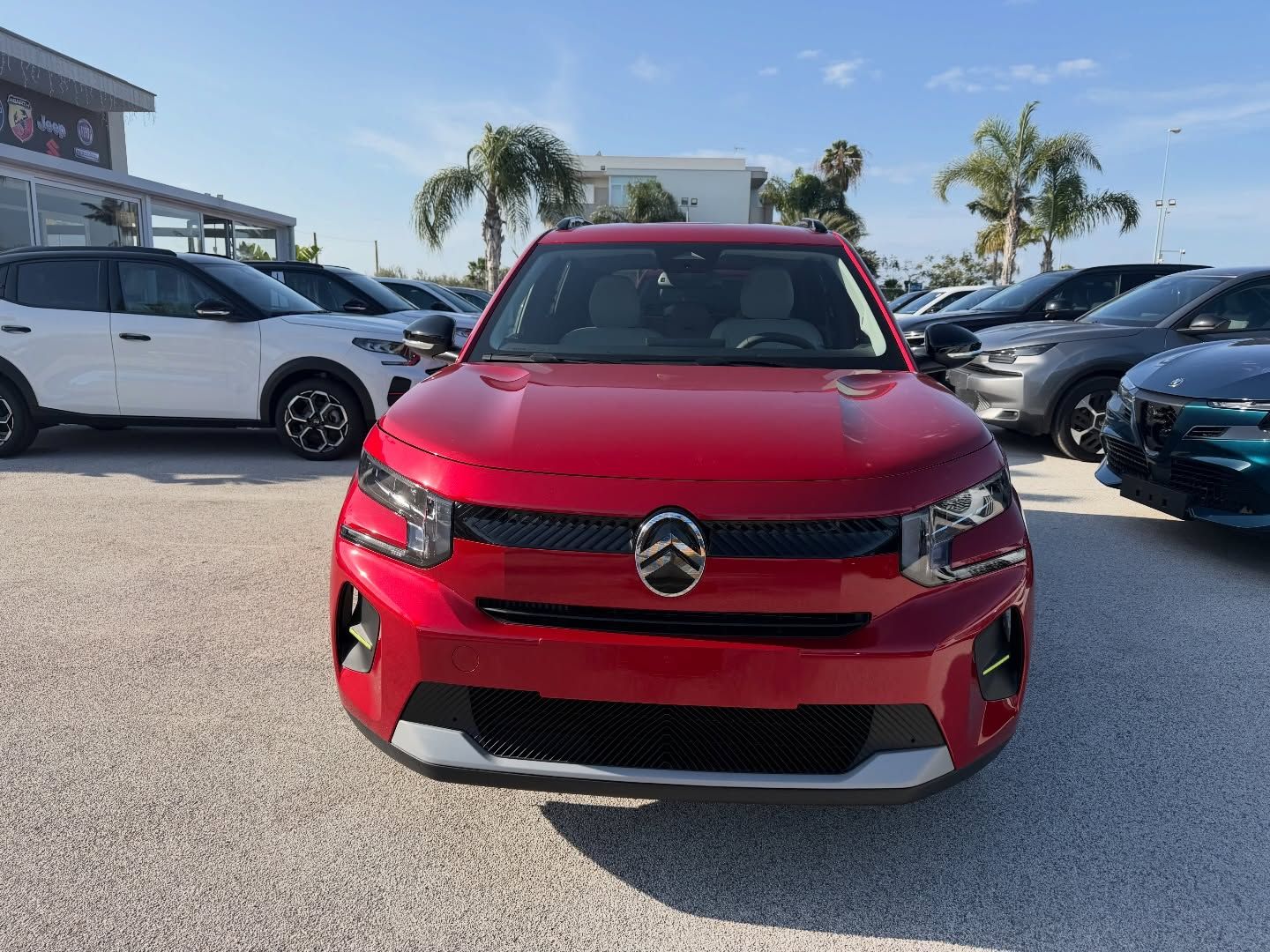 Un SUV Citroen rosso parcheggiato in un parcheggio in una giornata di sole.