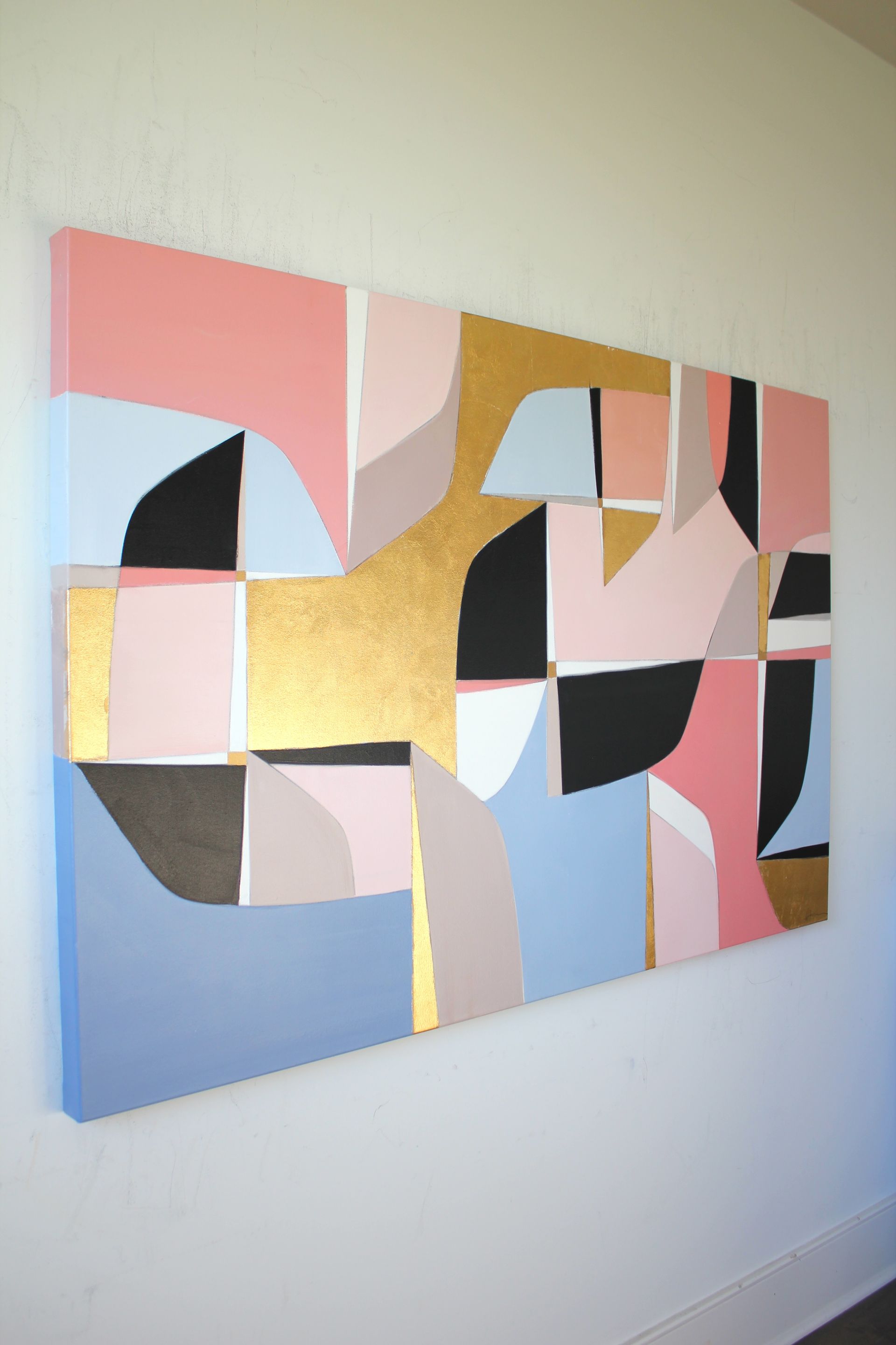 A large painting is hanging on a white wall
