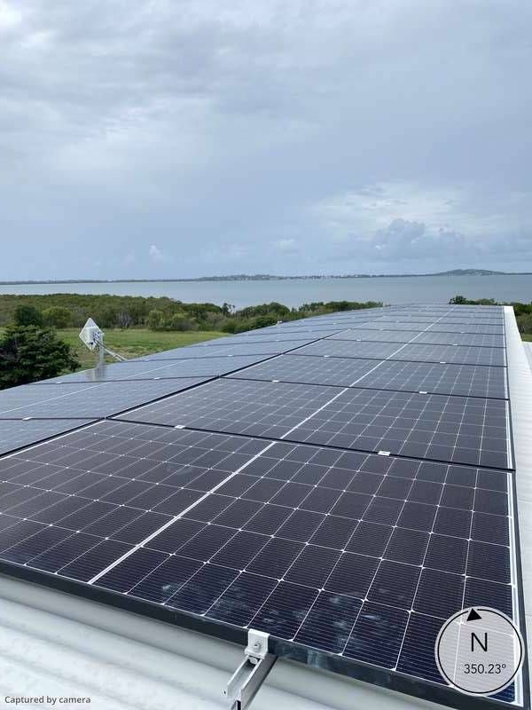 Large Solar Panels On A Roof Looking Towards The Sea — Solar Power Whitsunday In Bowen, QLD
