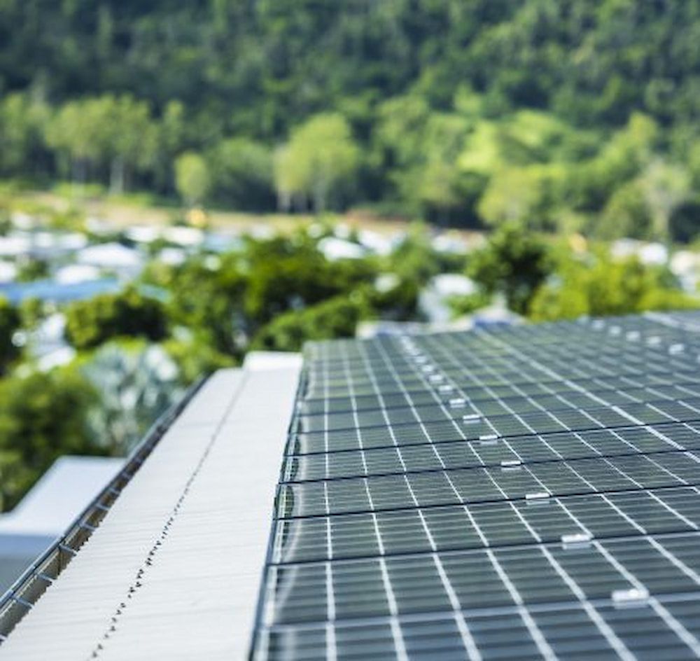 A Close Up Of A Solar Panel On A Roof With Trees In The Background — Solar Power Whitsunday In Cannonvale, QLD