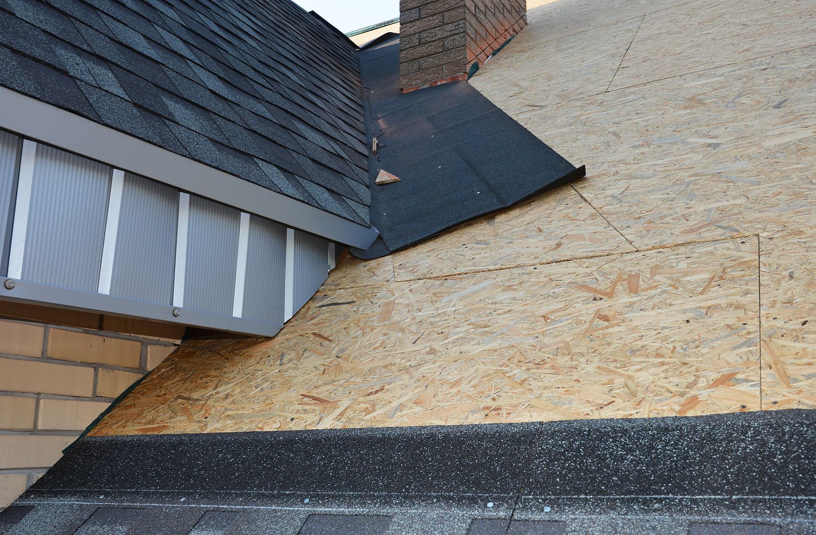 A roof is being installed on a brick building.