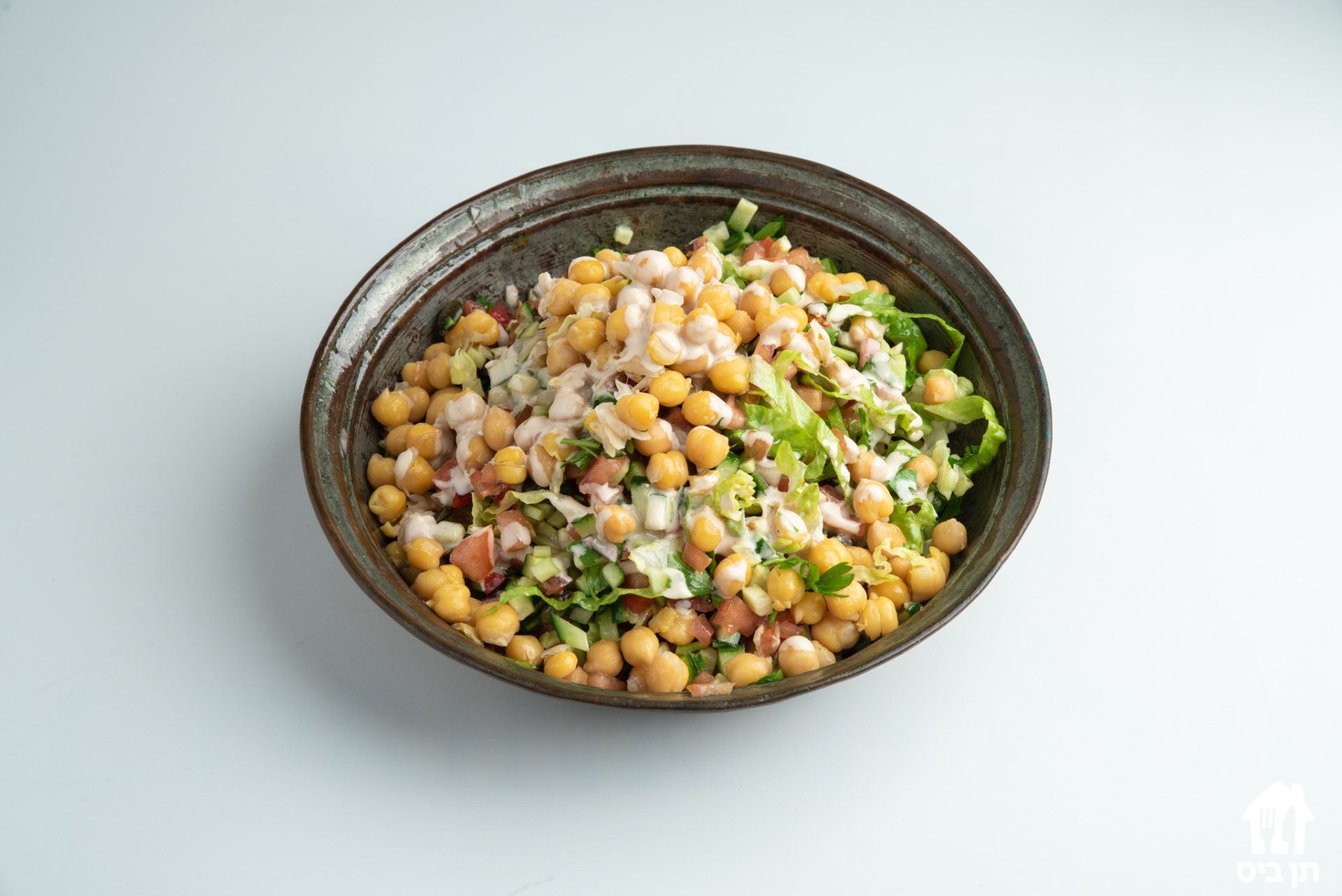 קערת חומוס וירקות על שולחן.