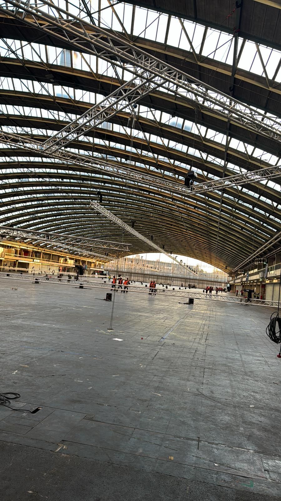 Large, empty industrial building with arched roof, trusses, and natural light.