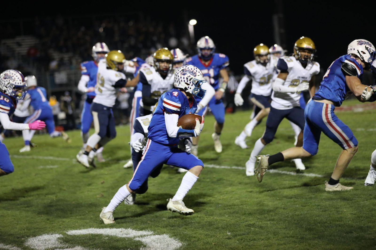 A group of football players are playing a game on a field.
