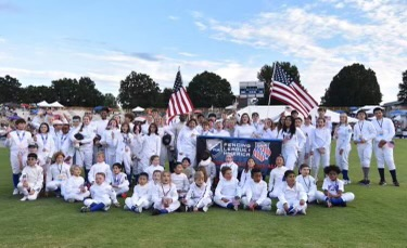 A group of children are posing for a picture on a field.